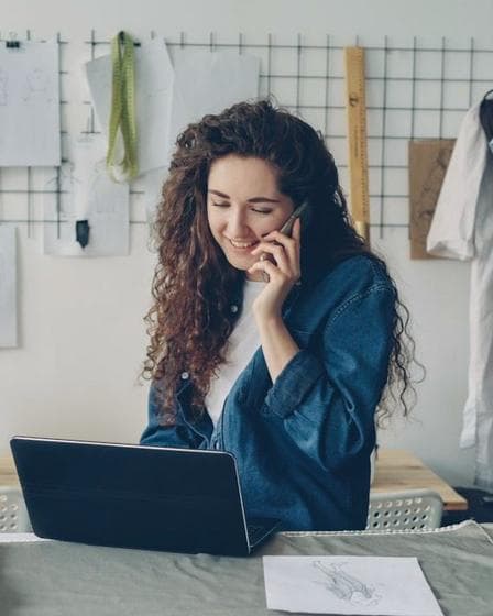 Ondernemer aan de telefoon achter haar laptop